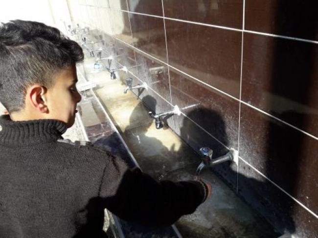 Boy washing hands at wash basin