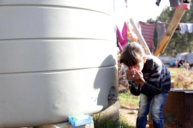 Lebanon - water supply used by little girl, photo by Ralph Yaacoub