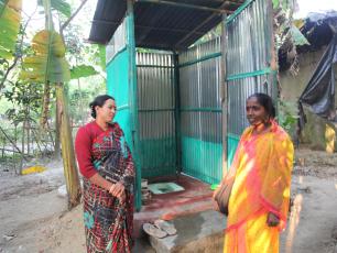 Fieldworker inspects village latrine in Mujaffarabad, Chittagong, Bangladesh.