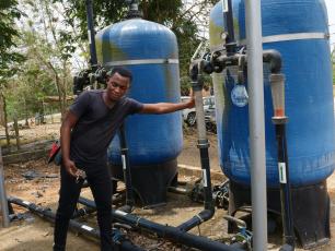 Eric Christford Mensah, CWSA technical engineer, demonstrates the alkaline treatment system that purifies water at Ekutuase