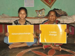 Young woman holding "#shemakeschange" card sitting next to old woman holding "#I make change", Odisha, India