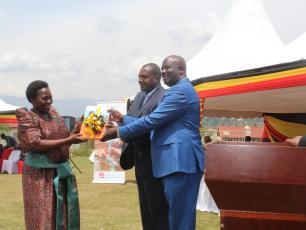 Minister of Local Government (left), receives copies of the district WASH Masterplan from Kabarole District Chairman (right)