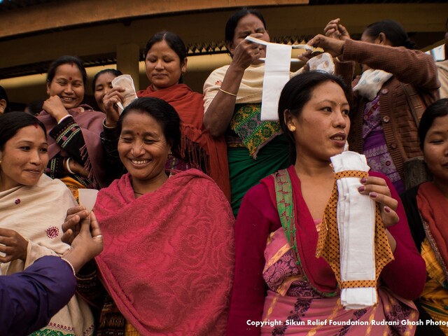 Women in India holding up sanitary products (Photo credit: Rudrani Ghosh photography)
