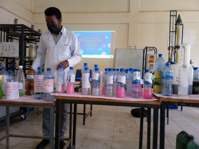 A trainer demonstrating the process of producing liquid soap in laboratory setting