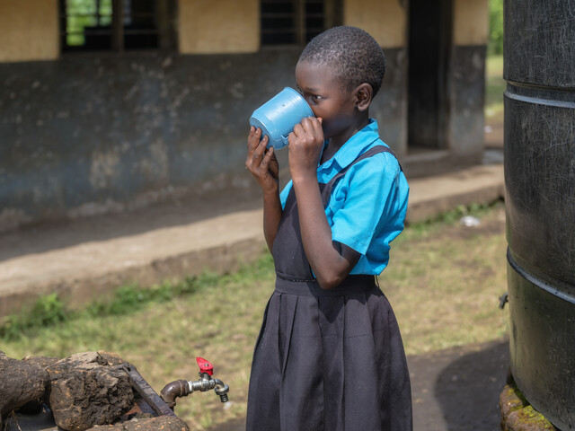 Girl drinking water in Fort Portal, Uganda 